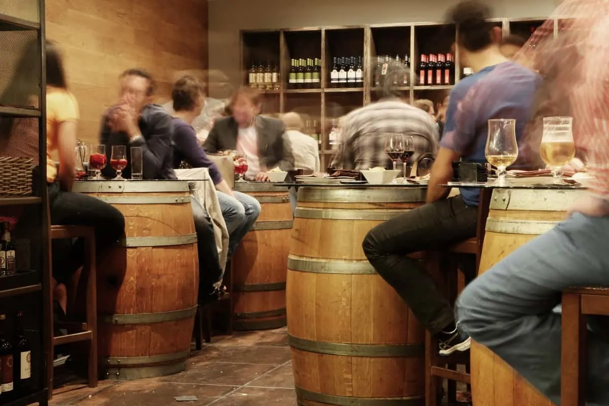 People drinking while sitting on barrel chairs