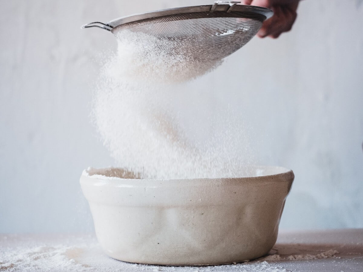 white sugar pouring in a bowl
