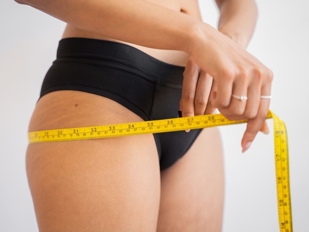 A girl measuring her waistline
