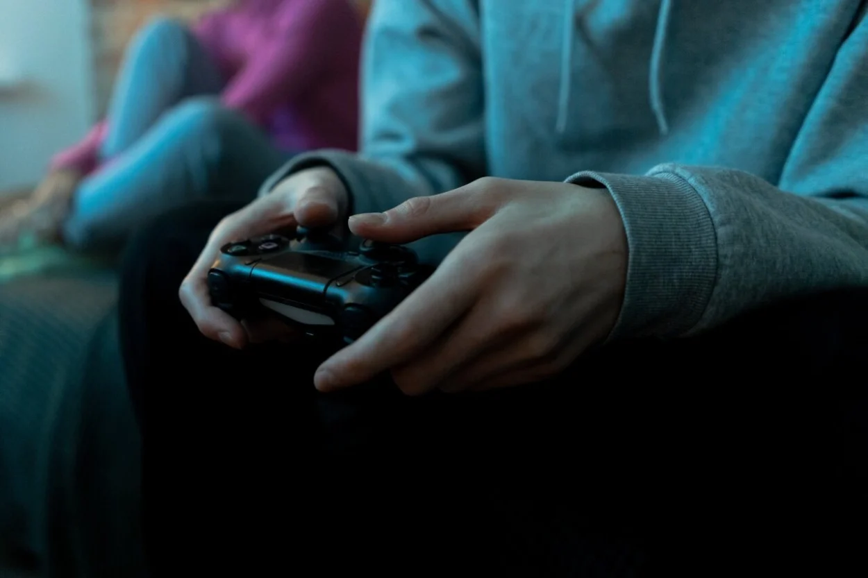 A hand holding a game console