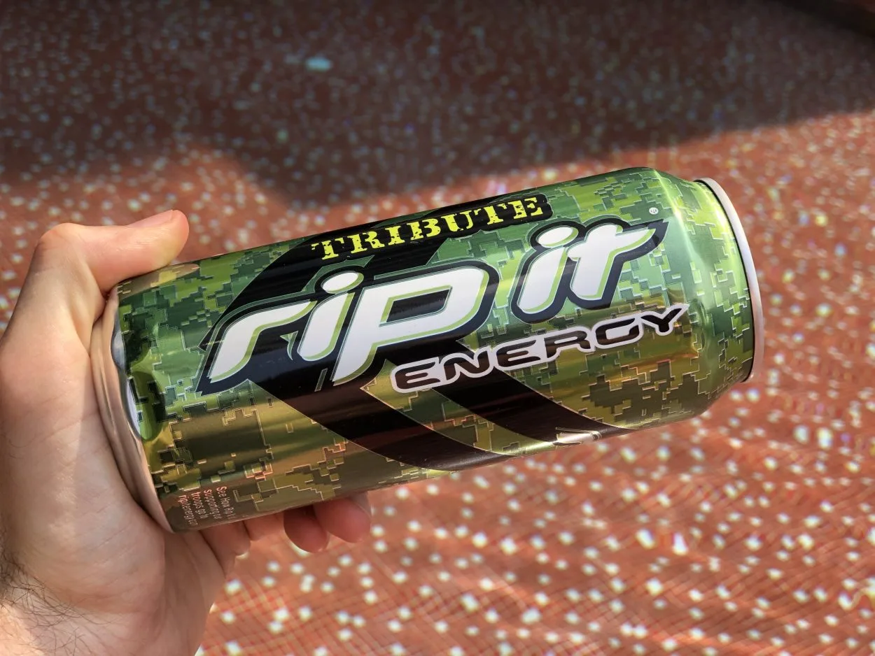 A person holding a can of Rip It horizontally