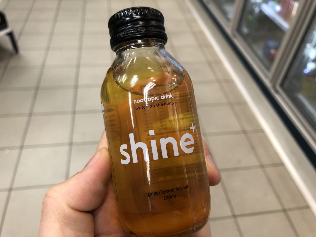 A person holding a bottle of Shine