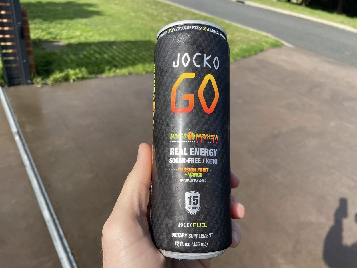 A person holding a can of Jocko Go in Mango flavor