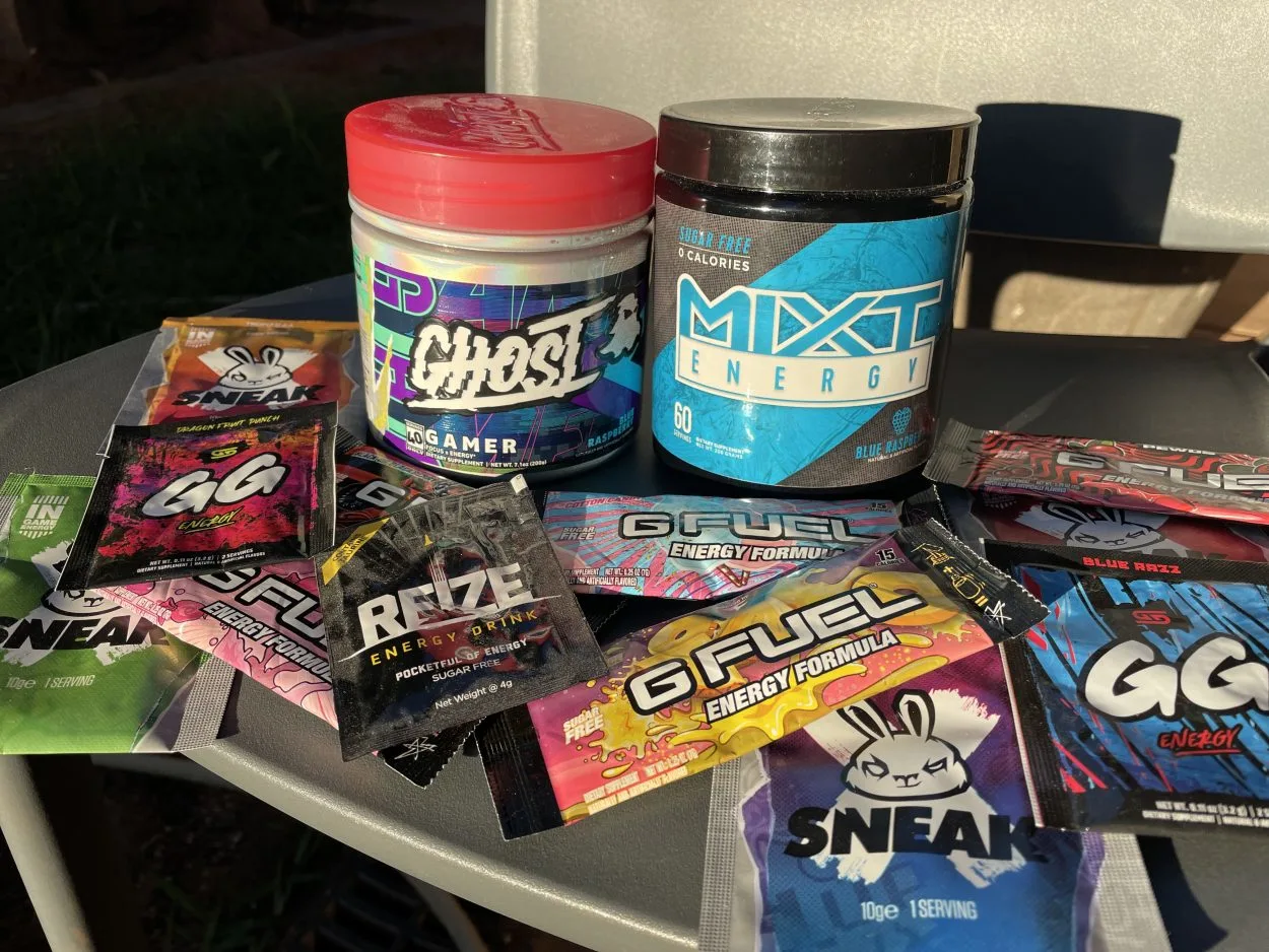 One tub of Ghose Gamer and one tub of Mixt Energy surrounded by different serving sized packets of energy drink
