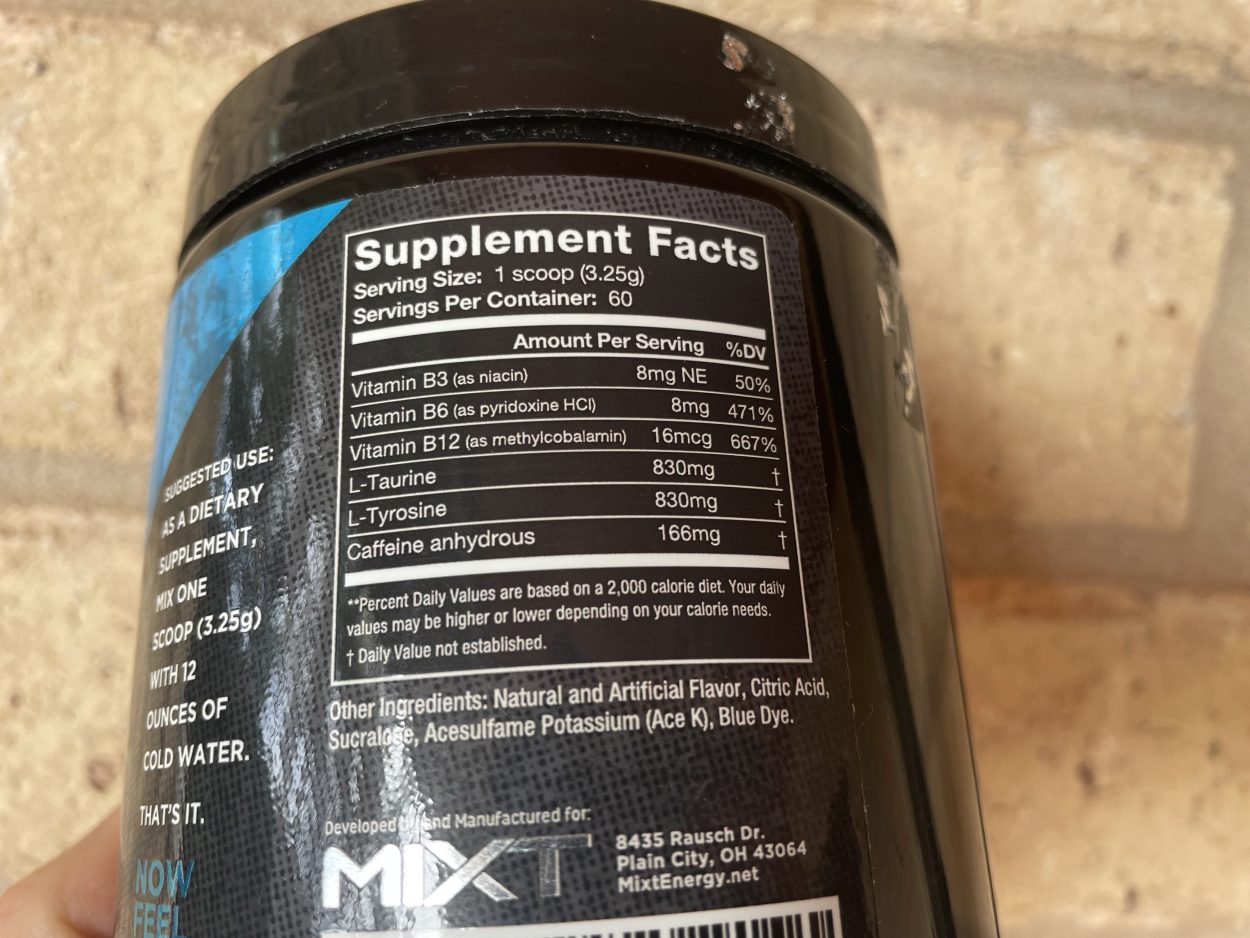 A person holding a tub of Mixt Energy and facing the nutritional facts