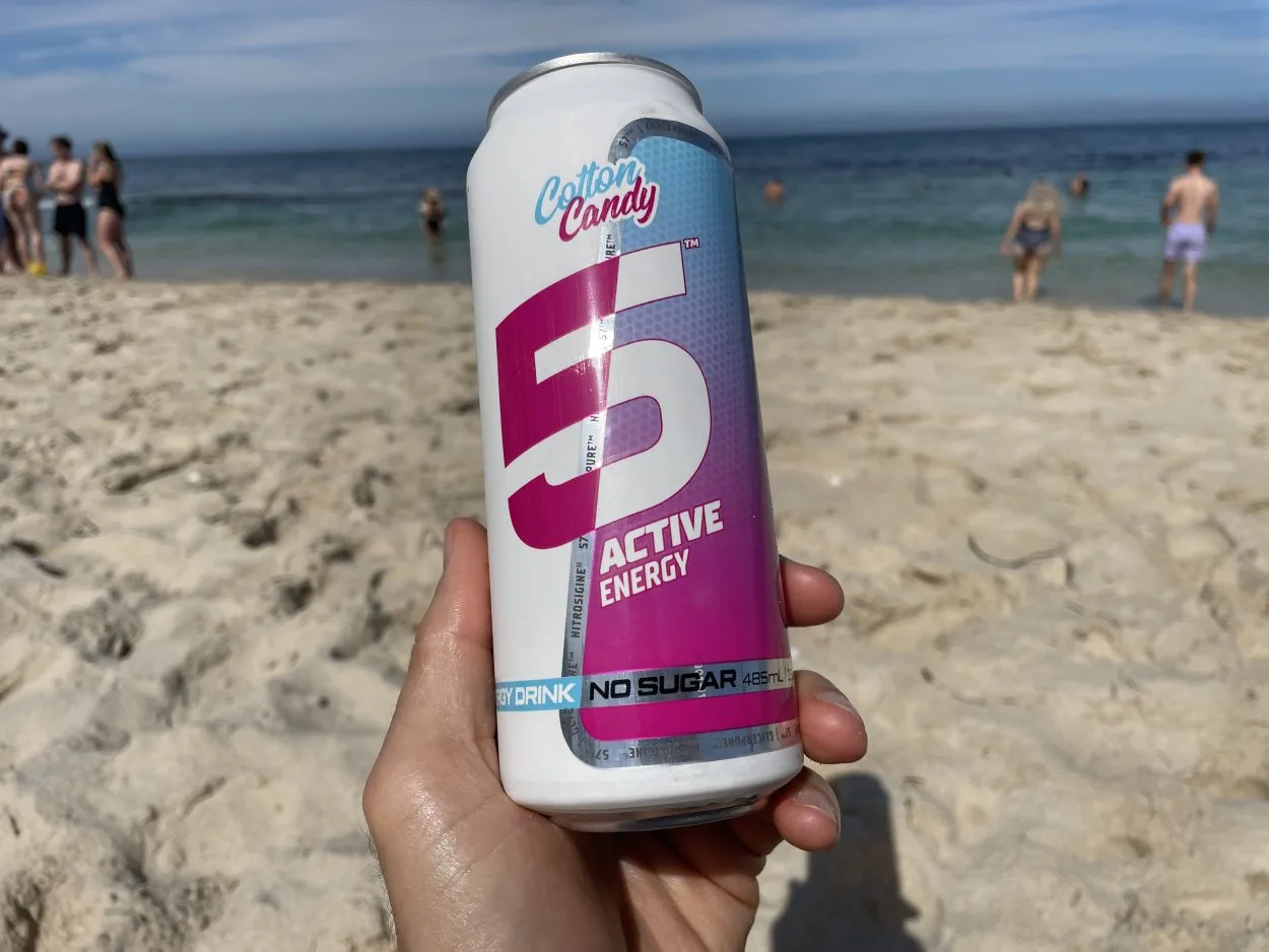 A person holding a can of 5 Active energy drink in Cotton Candy flavour