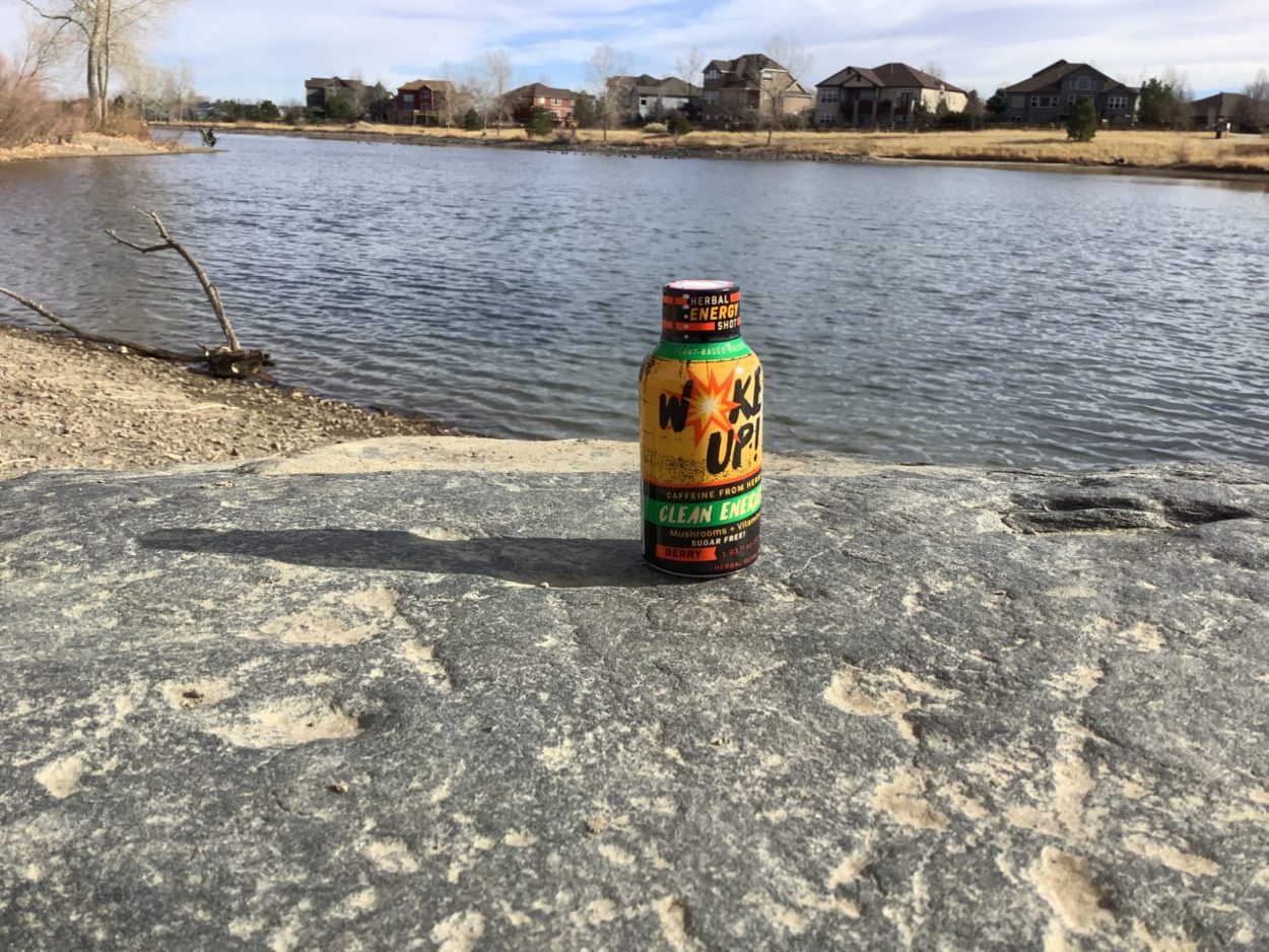 A shot of Woke Up placed on the rock with the lake behind it