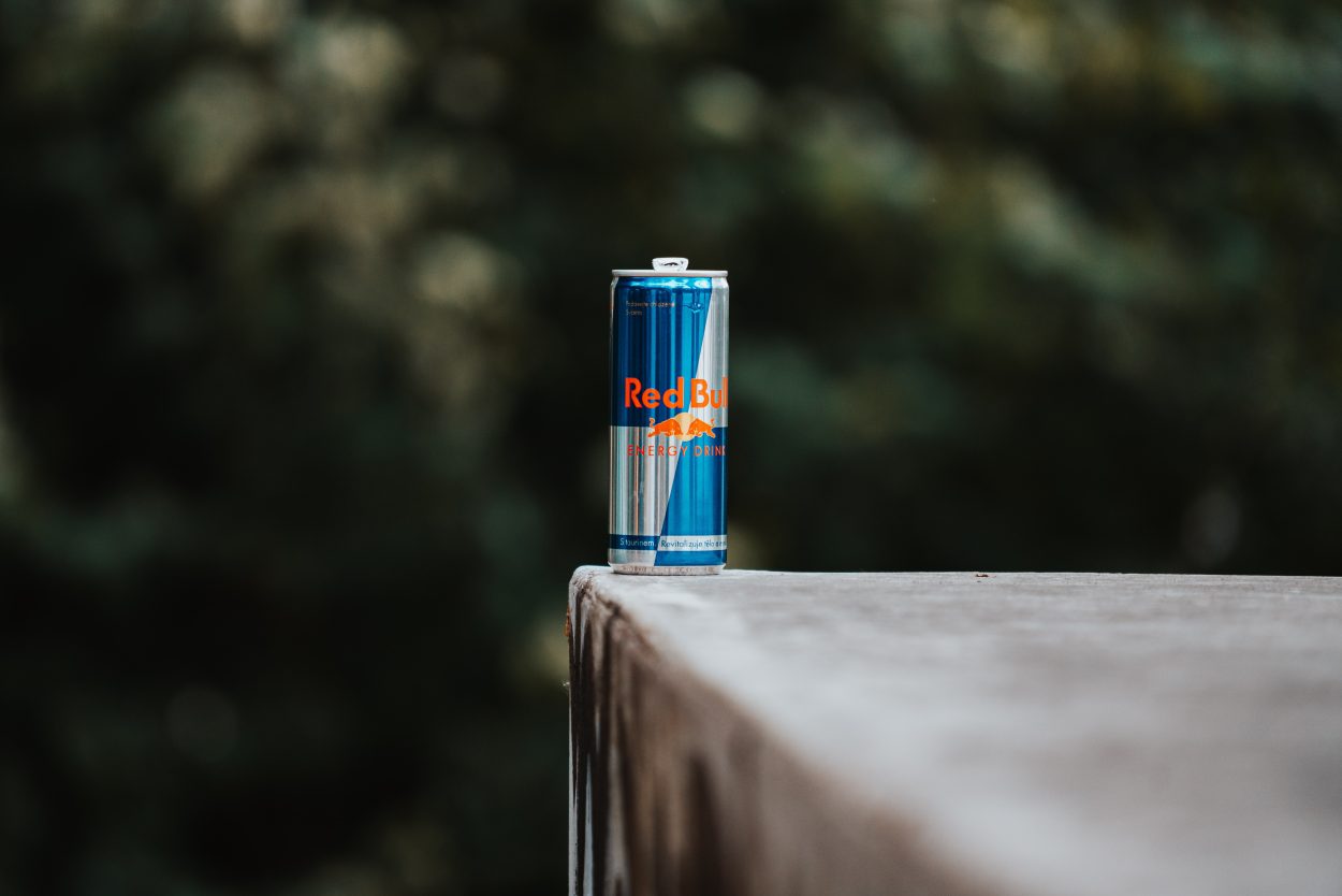 A can of Red Bull placed on edge of a surface