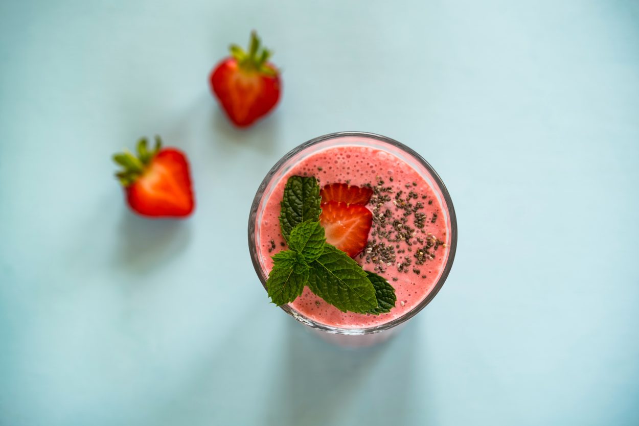 A glass of smoothie with mint and strawberry