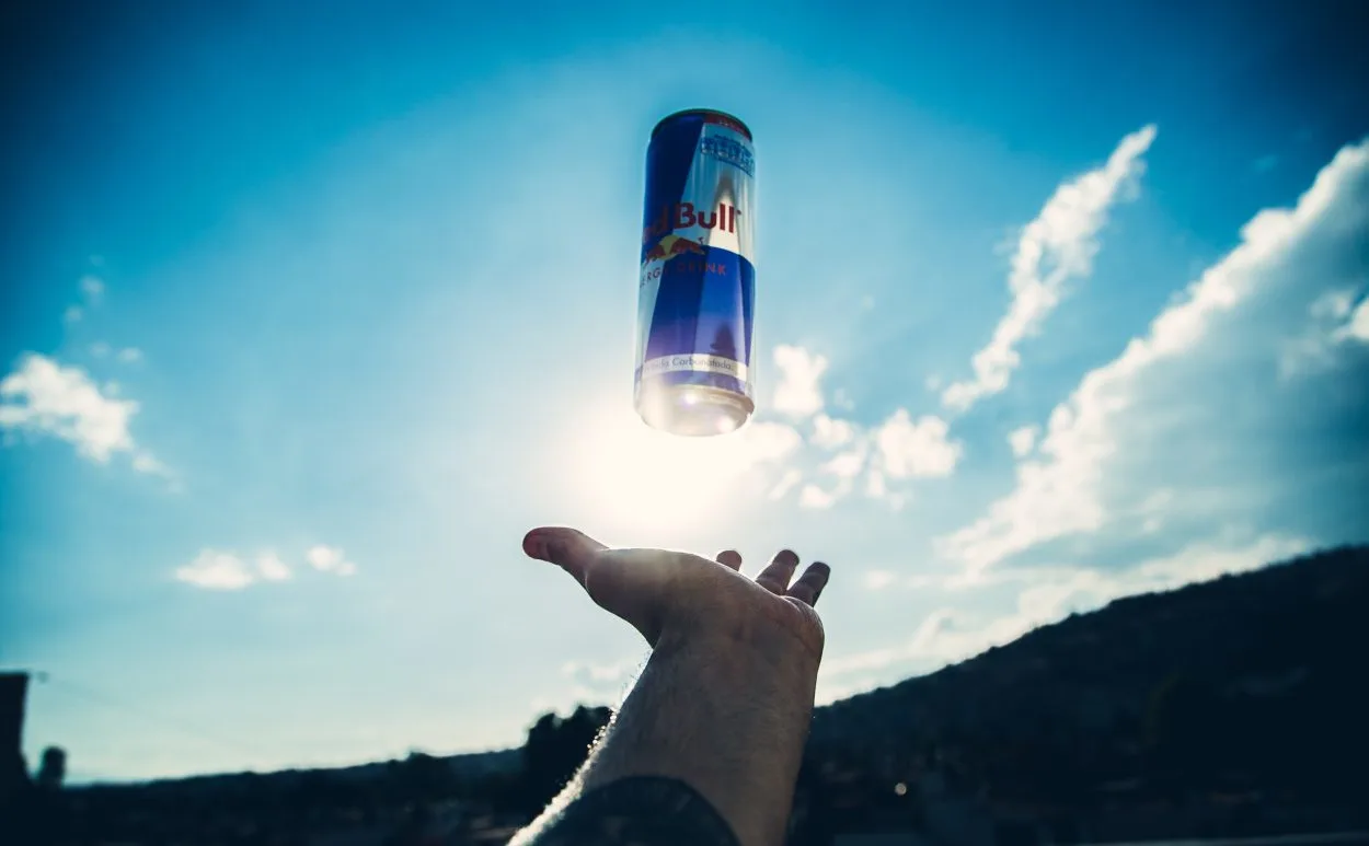 A can of Red Bull Original in air and a hand below it
