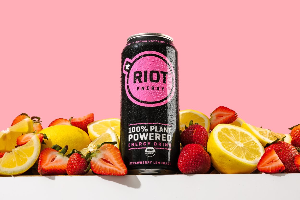 A can of Riot placed between lemons and strawberries