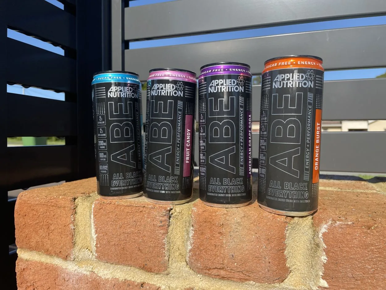 All four flavors of ABE energy drink placed on a brick wall