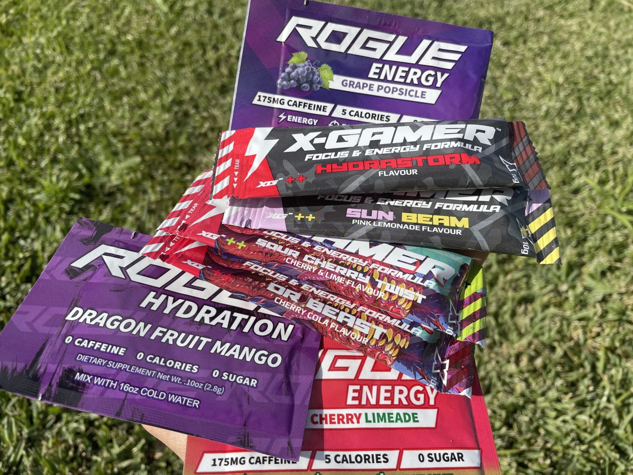 Sachets of Rogue energy and X Gamer in different flavors placed on the grass