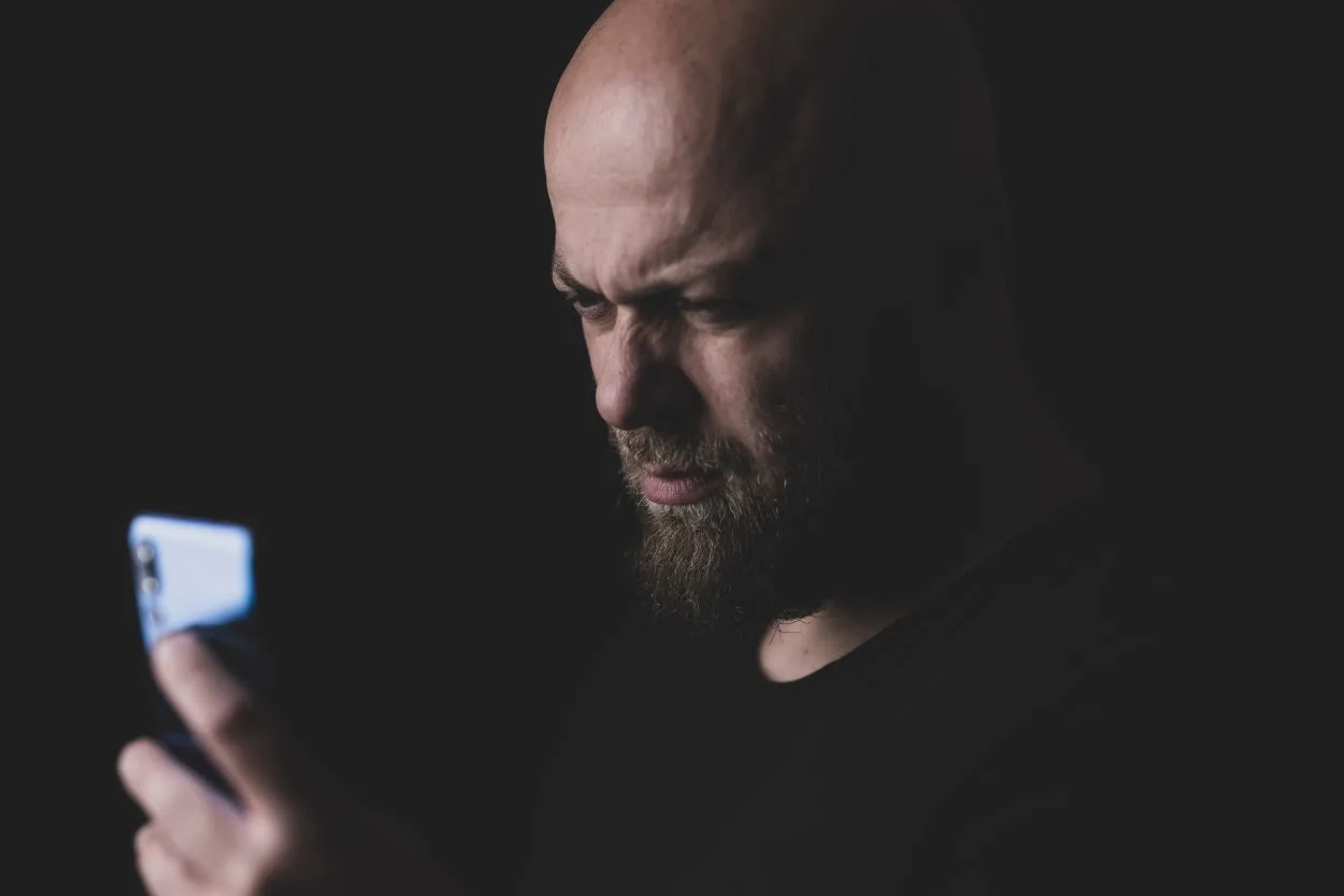 A man in black shirt looking at his phone